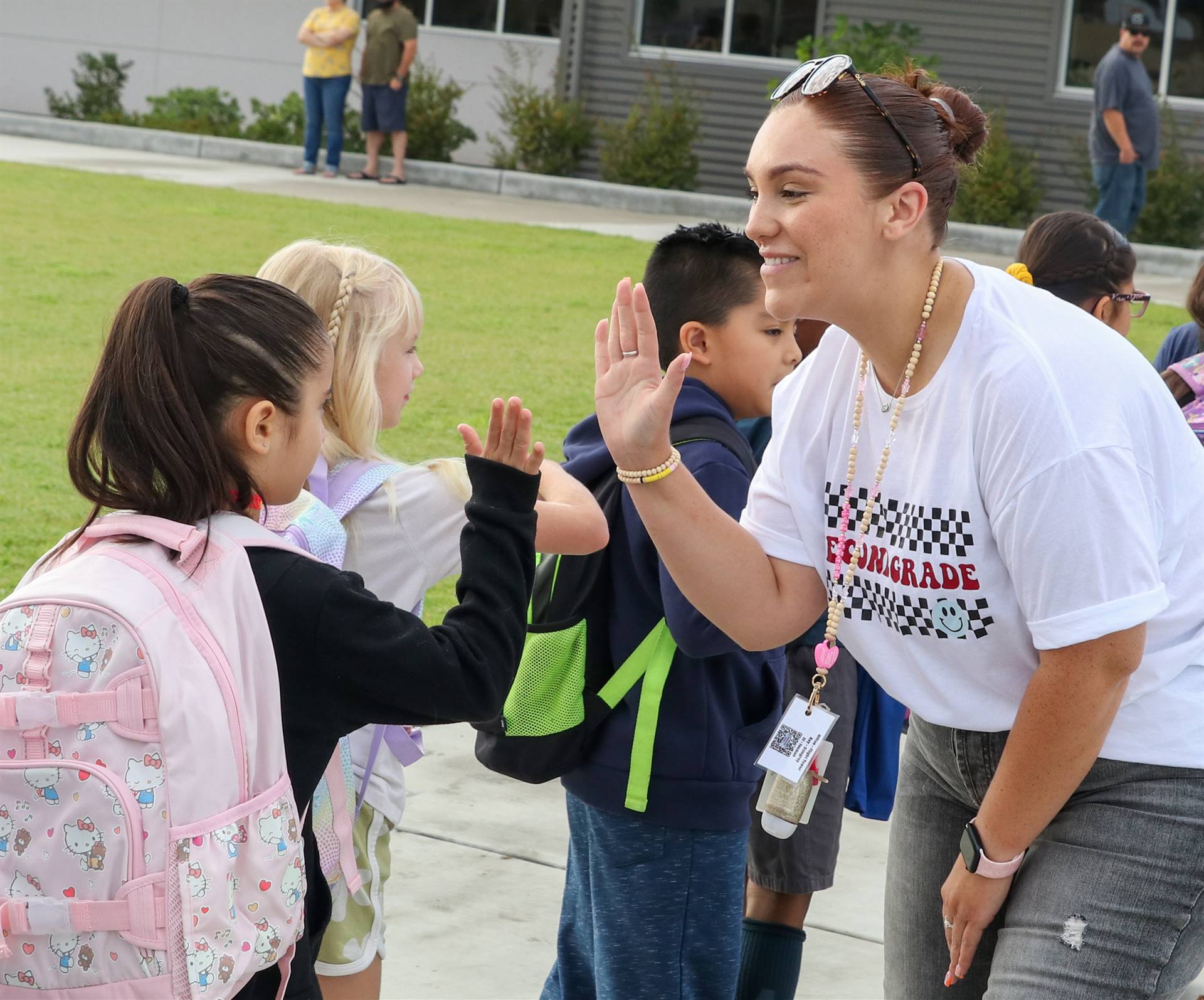 Teacher welcoming student on first day of school with a high-five.