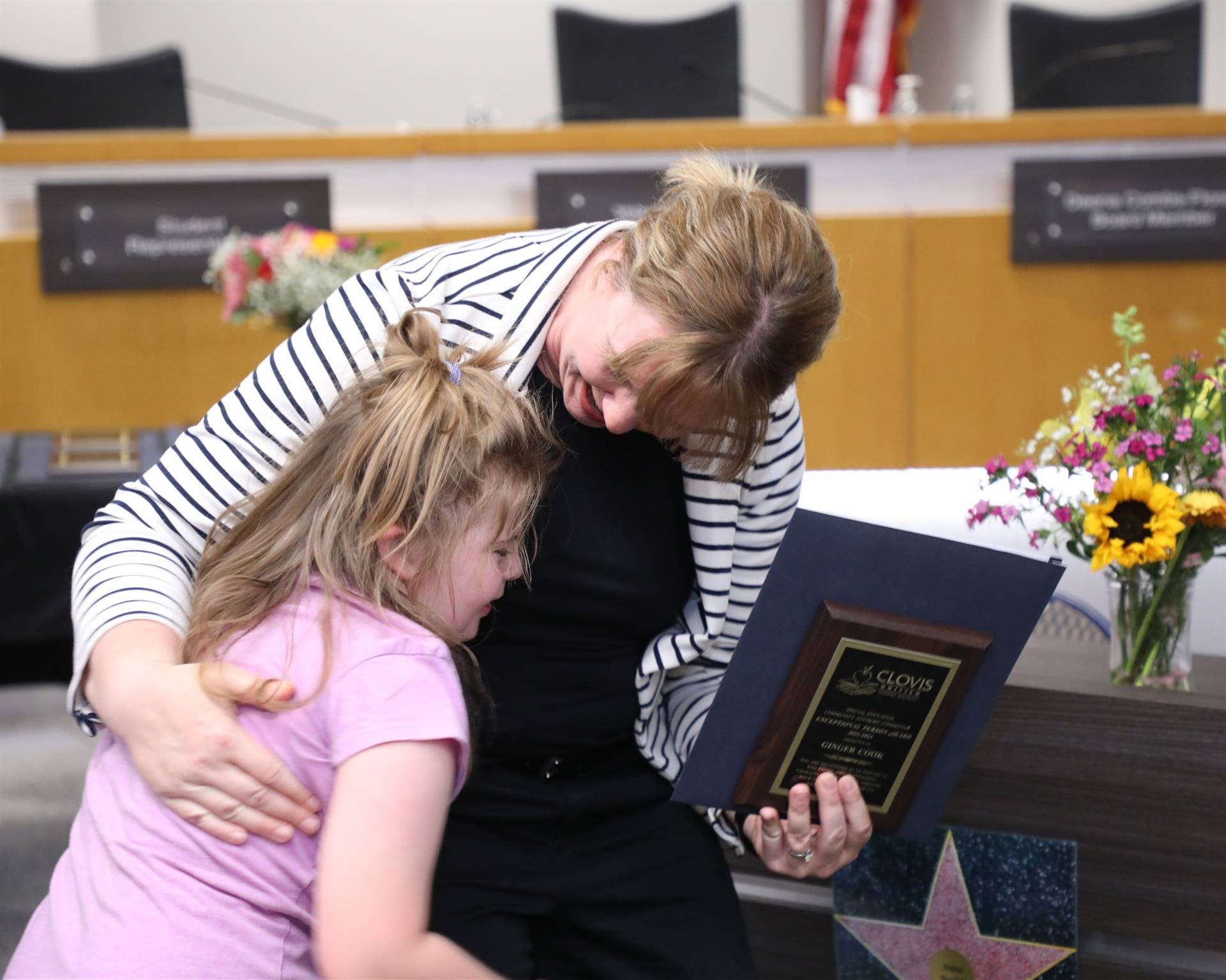 Ginger Cook hugging a young girl after receiving her award